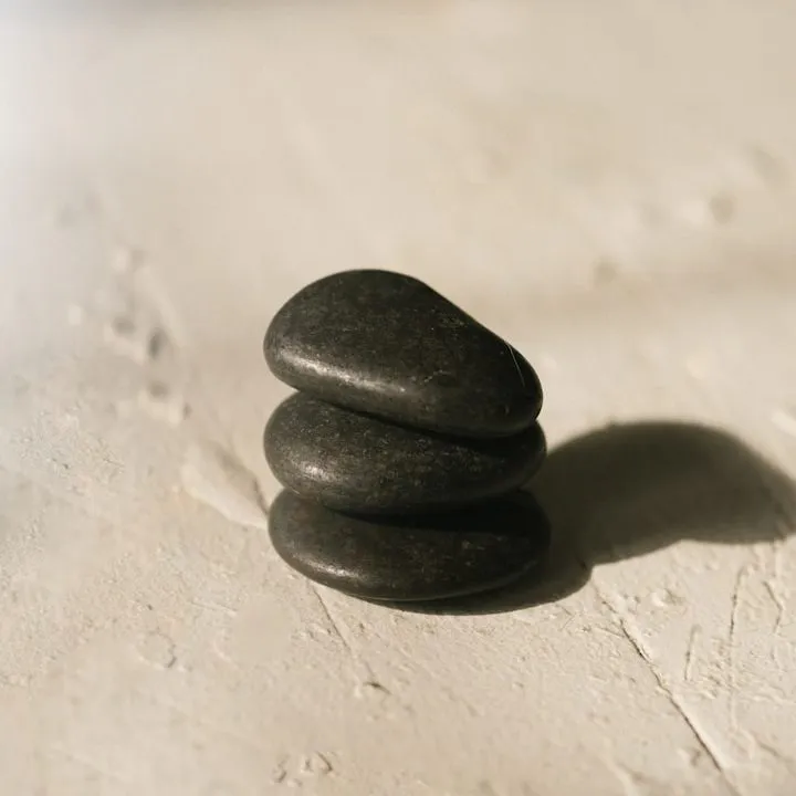 Smooth warm stones stacked on a pale surface